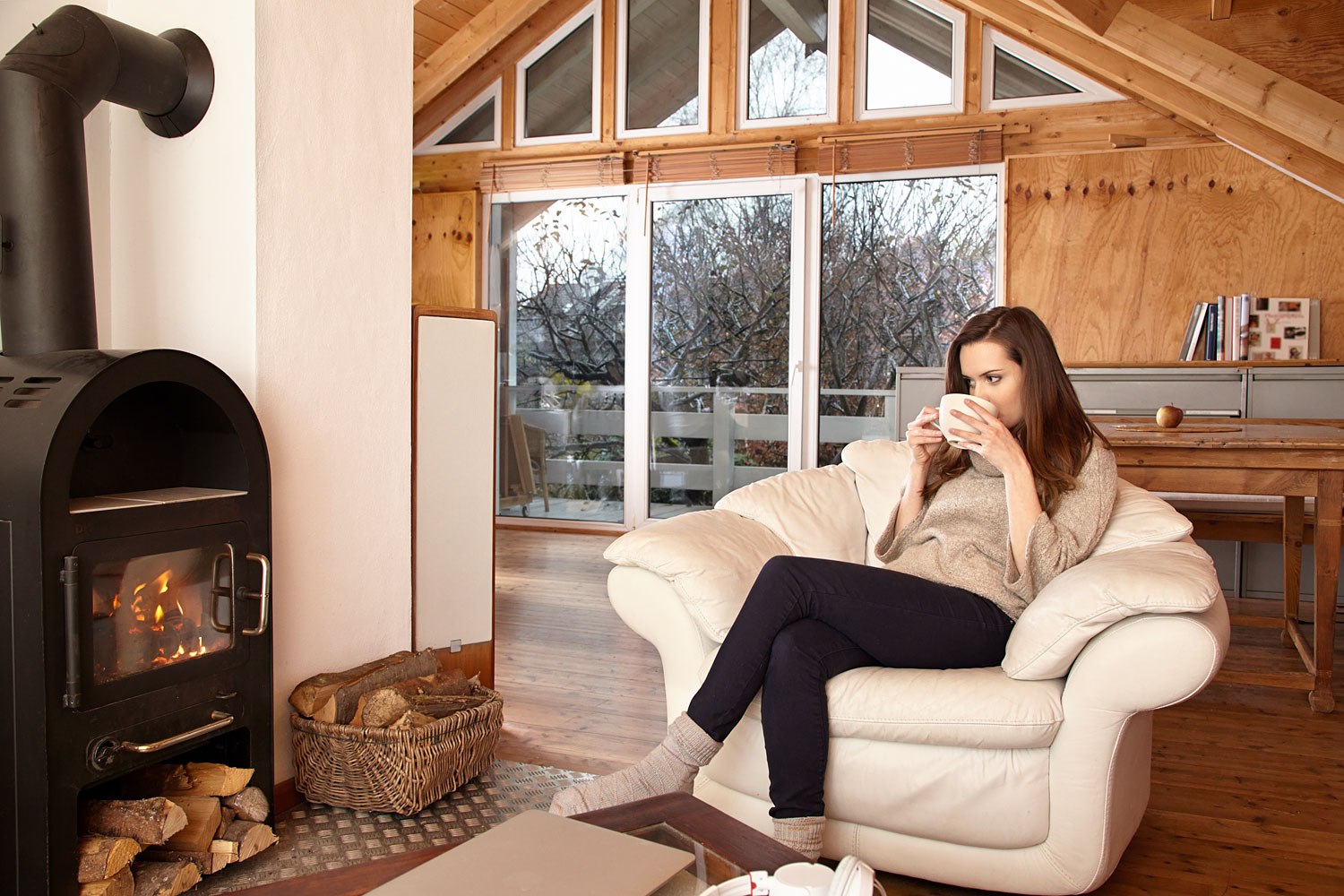 Frau mit Kaffee vor dem Kamin